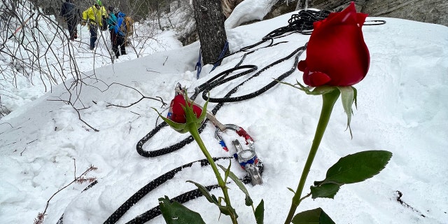 Flowers were placed in the snow near where the woman died after becoming trapped under two large blocks of fallen ice.