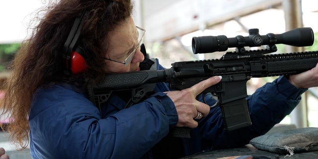 Woman learns to shoot AR-15 at outdoor rifle range