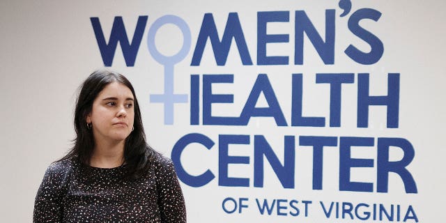 The Women's Health Center of West Virginia Executive Director Katie Quiñonez stands in front of the center’s sign in Charleston on Feb 25, 2022. The center has dropped its federal lawsuit seeking to overturn the state’s near-total abortion ban.