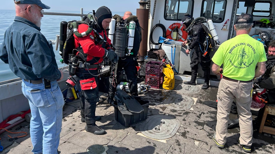 Esta foto, fornecida pela Shoreline Diving Services, mostra a equipe se preparando para mergulhar nos destroços do submarino de ataque de 92 pés Defender, sexta-feira, 14 de abril de 2023, que foi afundado pelo Corpo de Engenheiros do Exército em 1946. (Jennifer Sellitti/ Shoreline Serviços de Mergulho via AP)