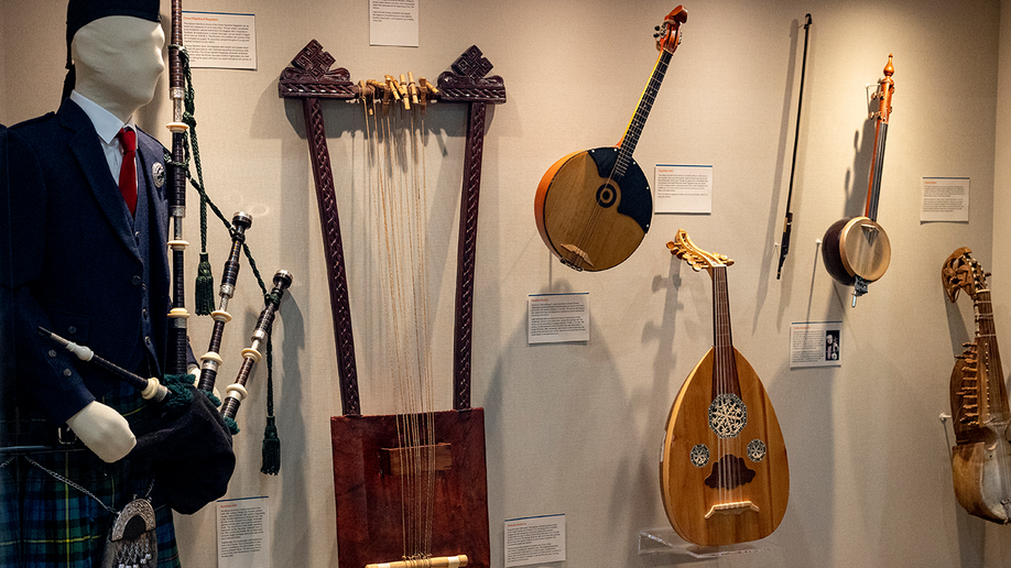 A mannequin with bagpipes and Various instruments on display at the Unclaimed Baggage Museum.