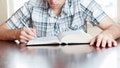 TORONTO, ONTARIO, CANADA - 2013/03/24: Male teenager reading and studying the Bible or preparing for school by studying his textbook and taking notes. (Photo by Roberto Machado Noa/LightRocket via Getty Images)
