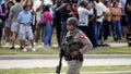 A law enforcement officer walks as people are evacuated from a shopping center where a shooting occurred Saturday, May 6, 2023, in Allen, Texas. (AP Photo/LM Otero)