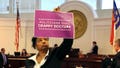 North Carolina Democratic state Sen. Kandie Smith holds up a sign that reads "Politicians Make Crappy Doctors" on the Senate floor in Raleigh, after the chamber voted to approve new abortion restrictions on May 4, 2023.