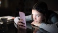 Worried woman checking smart phone in the dark night