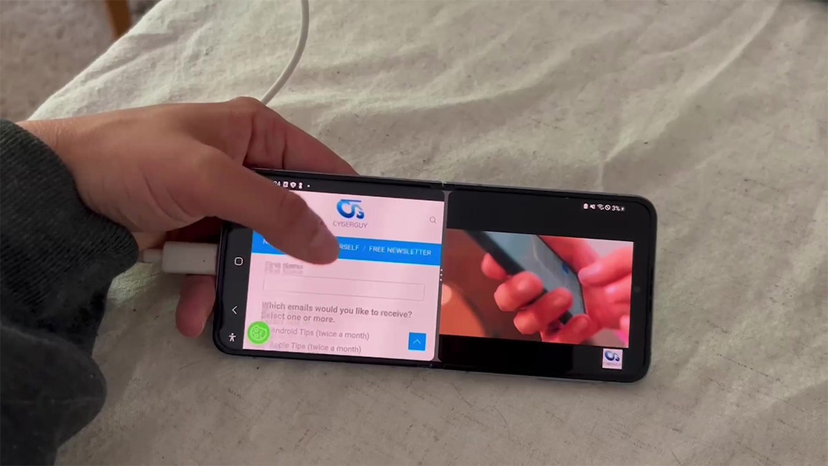 Person holding an Android phone showing the split screen.