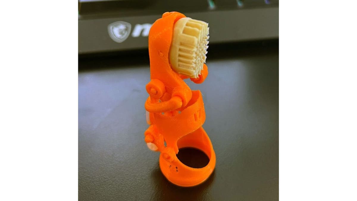 Orange pinky 3D-printed prosthetic finger 