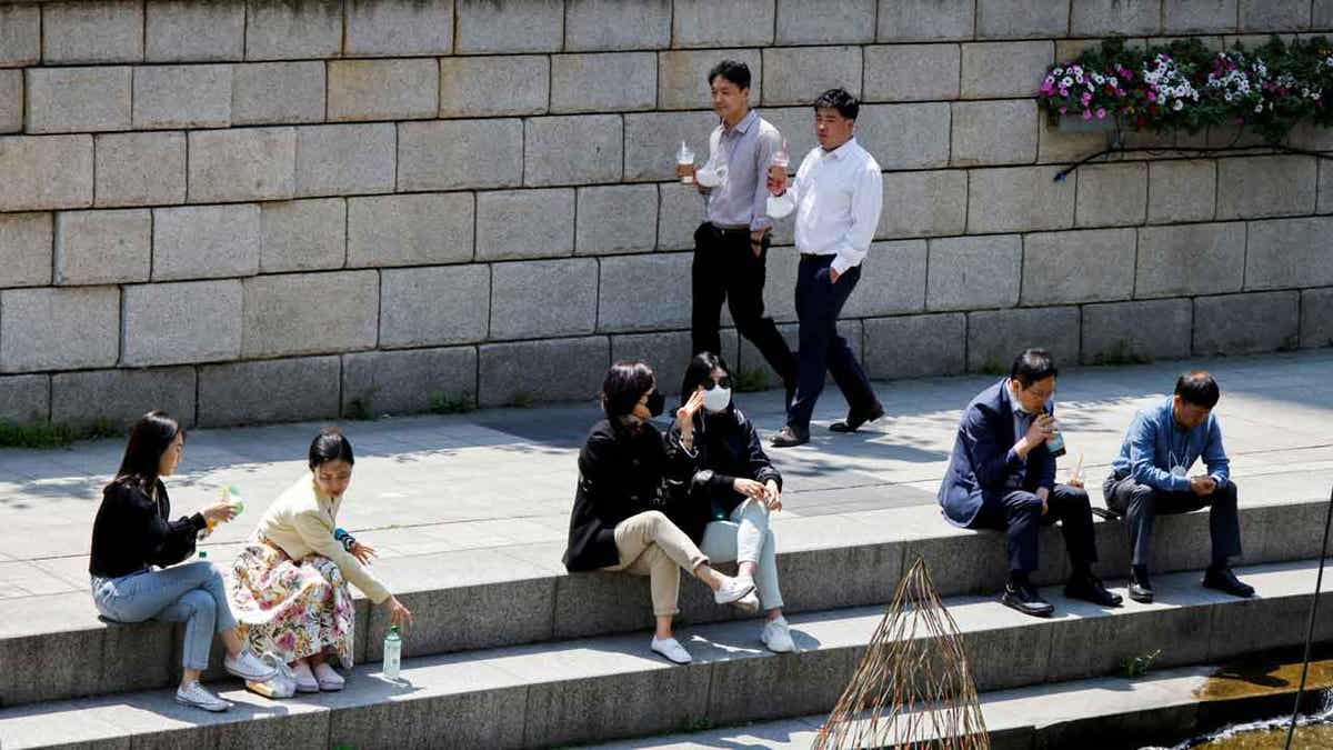 People walk on a sunny spring day in Seoul