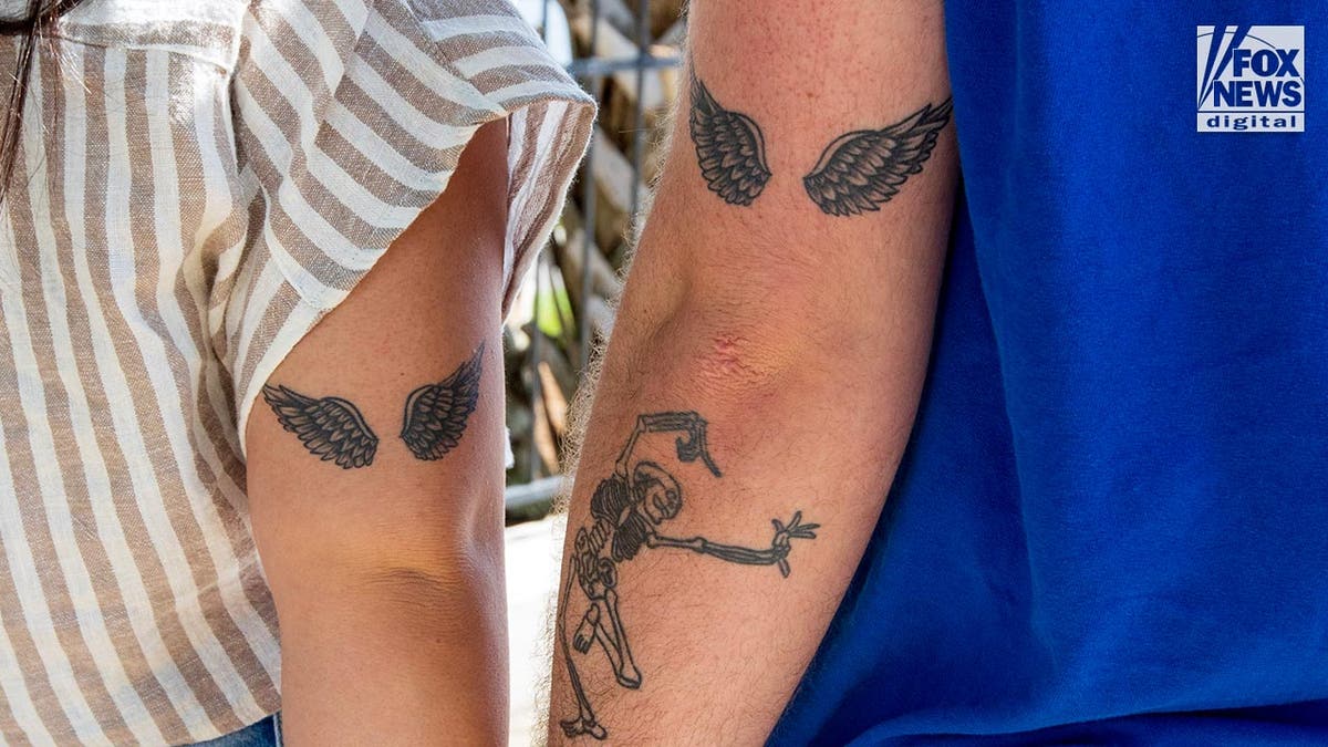 Heróis de Madison Brooks com tatuagens correspondentes de asas de anjo em seus braços