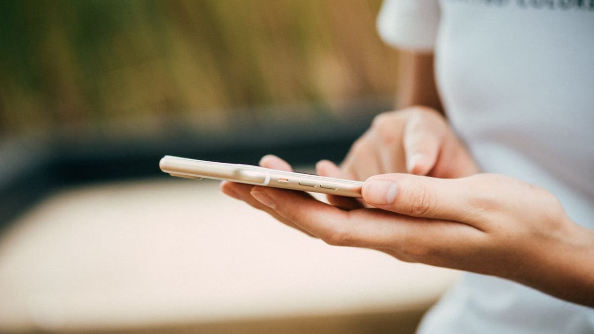 Up close hands of woman holding iPhone