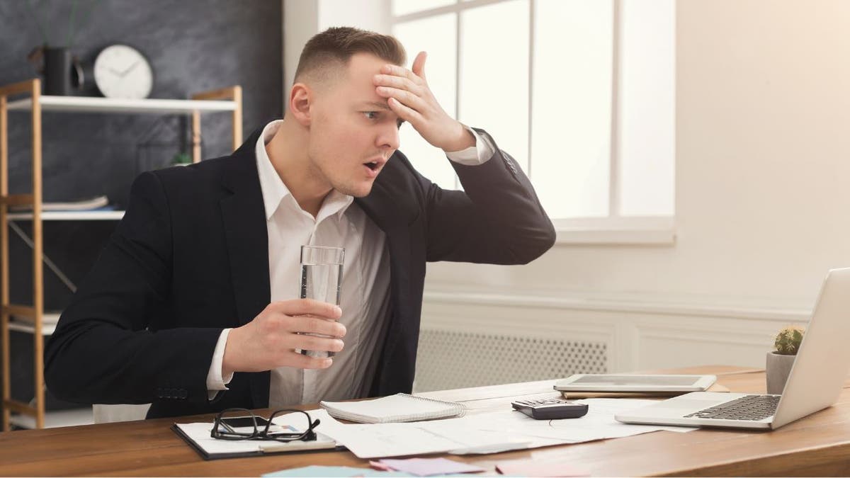 A picture of a man stressed out on his computer