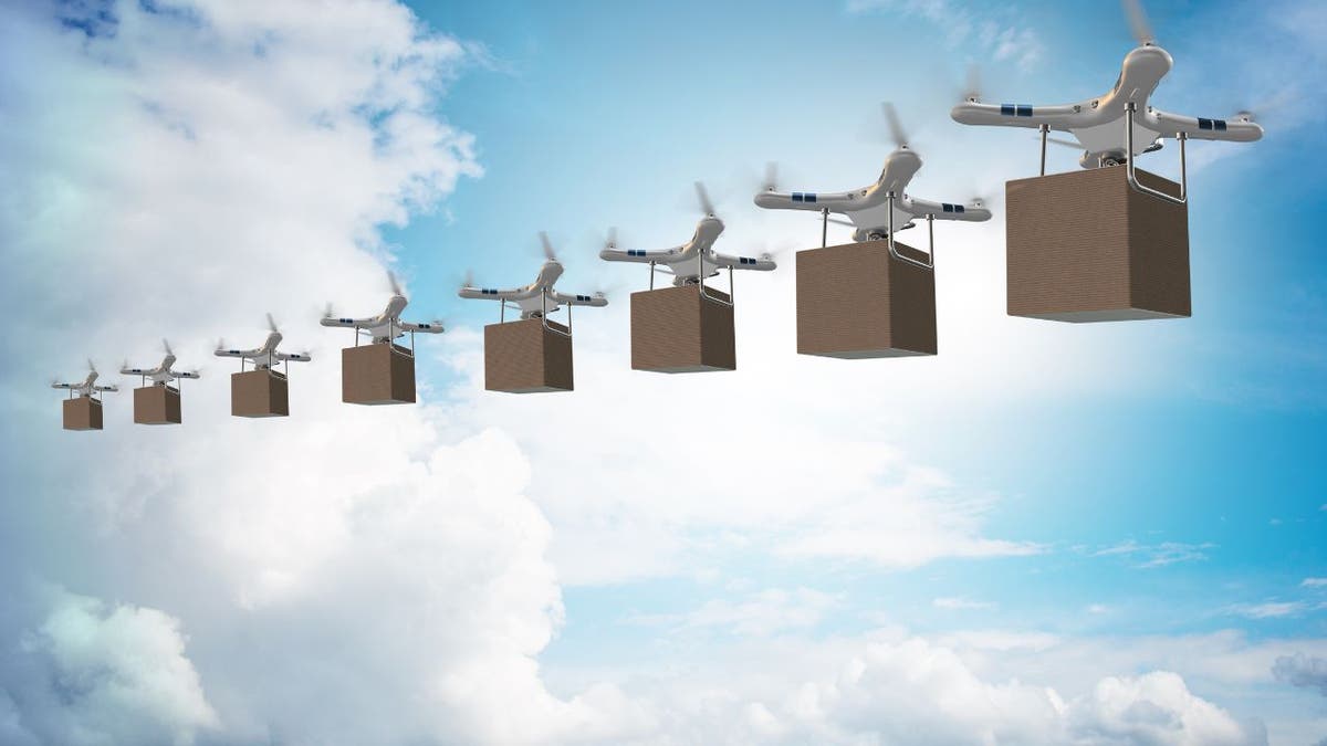 Multiple drones carry boxes while in the sky