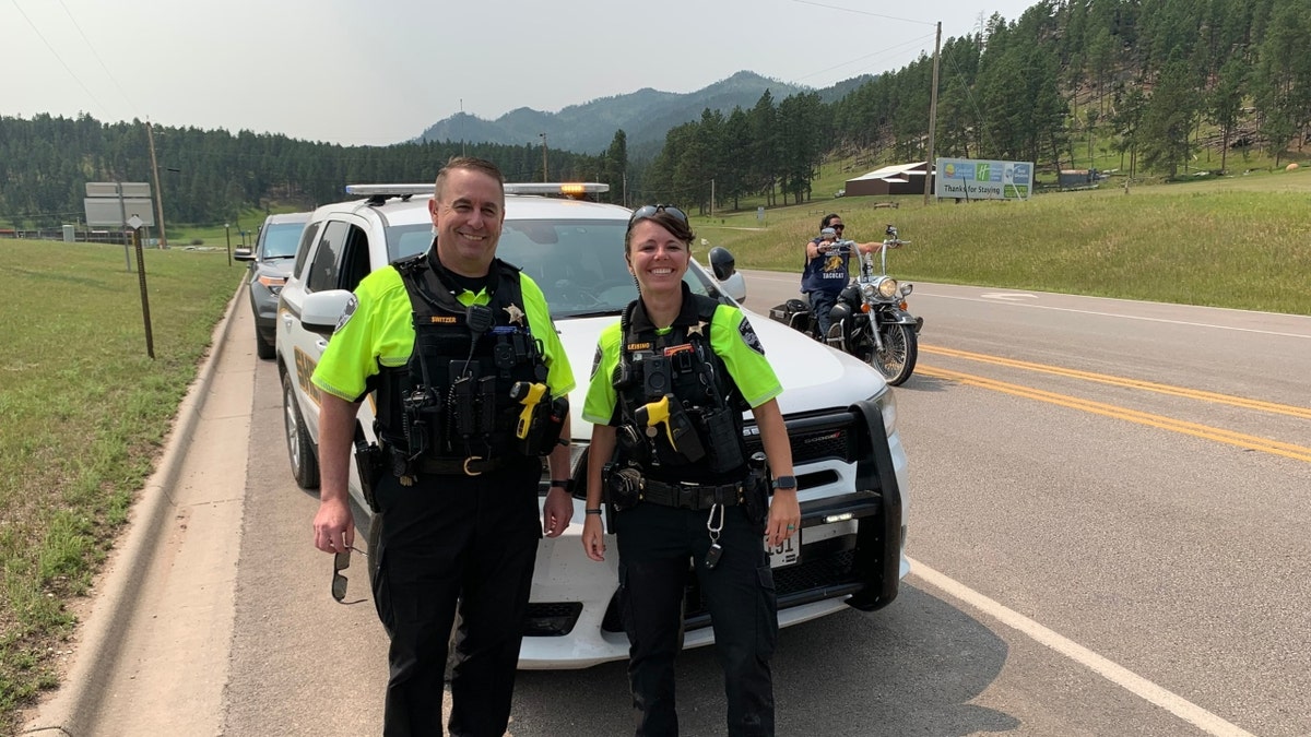 Croix County Sheriff’s Office Deputy Kaitie Leising poses next to another deputy with mountains in the background