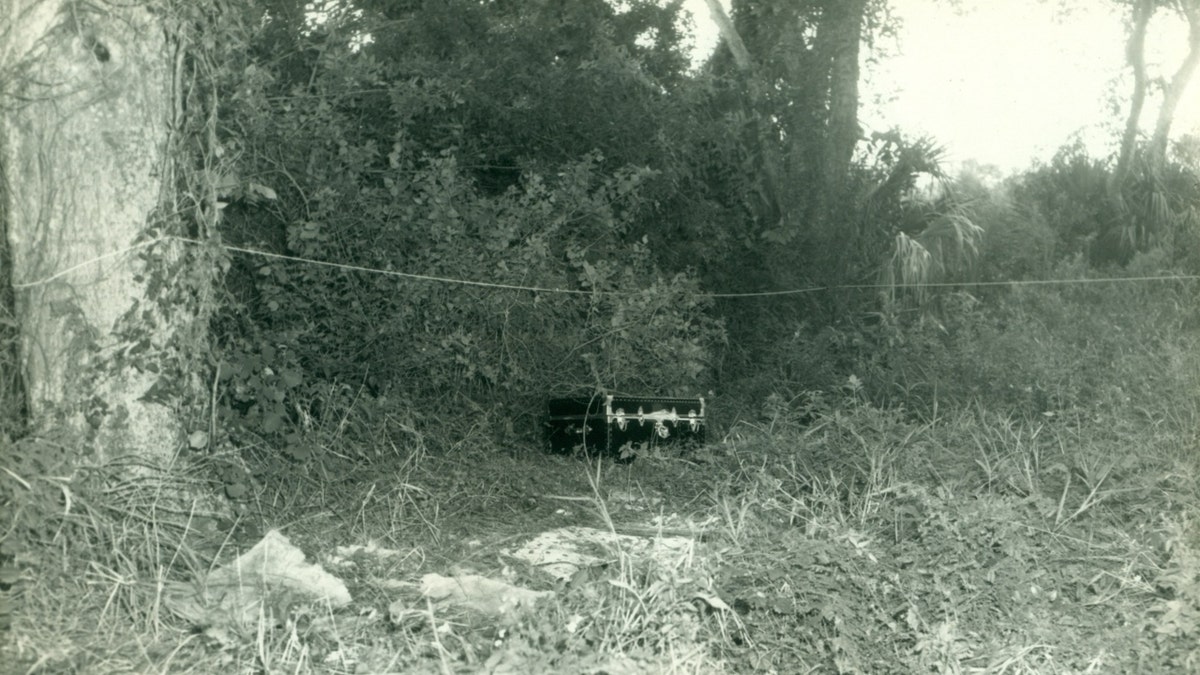 The black wooden trunk where Atherton's remains were found photographed in a wooded area