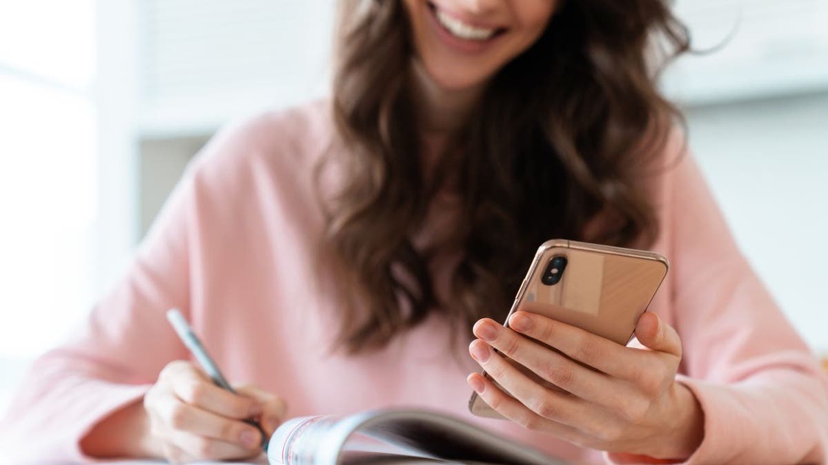 Woman in pink shirt with smartphone