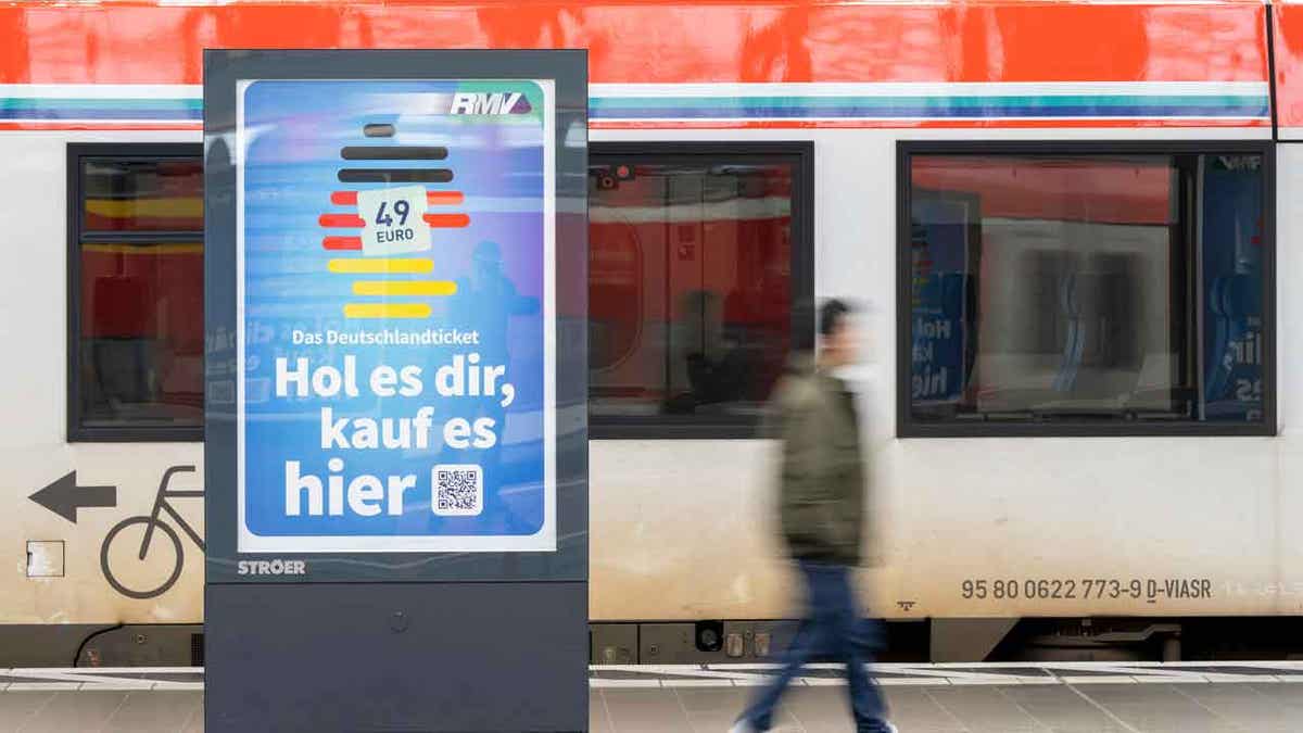 A man passes by an advertising for the Deutschlandticket