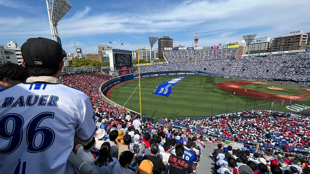 A crowd watches Trevor Bauer pitch