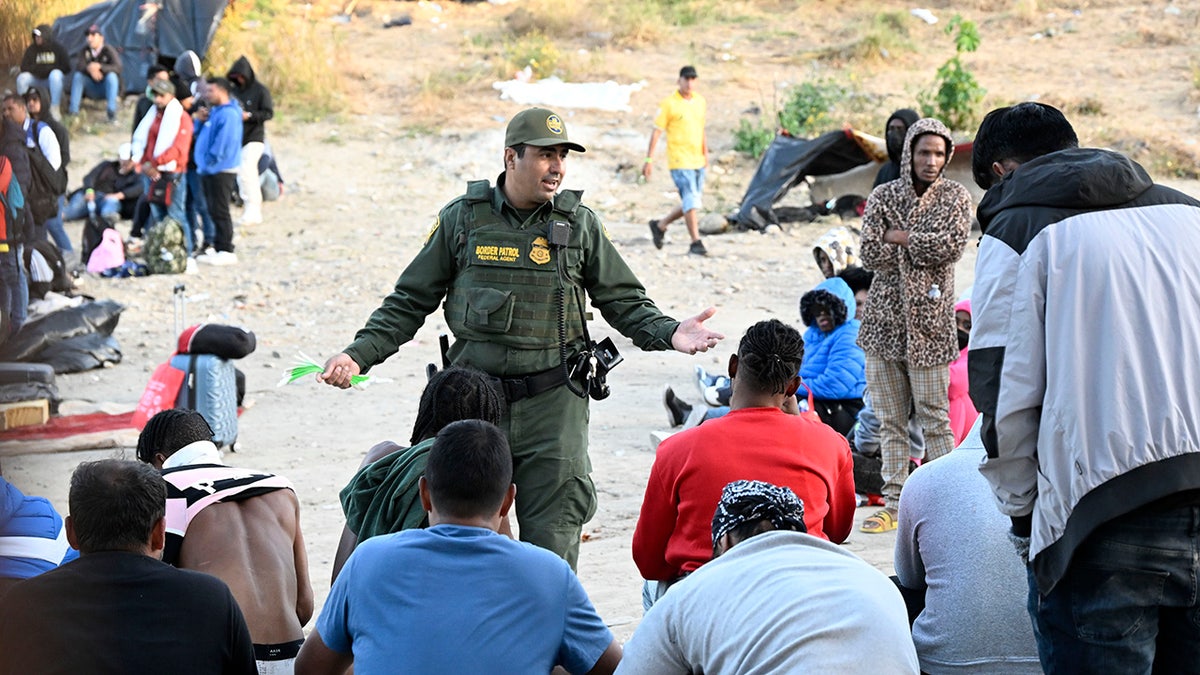 Border guard speaks to migrants