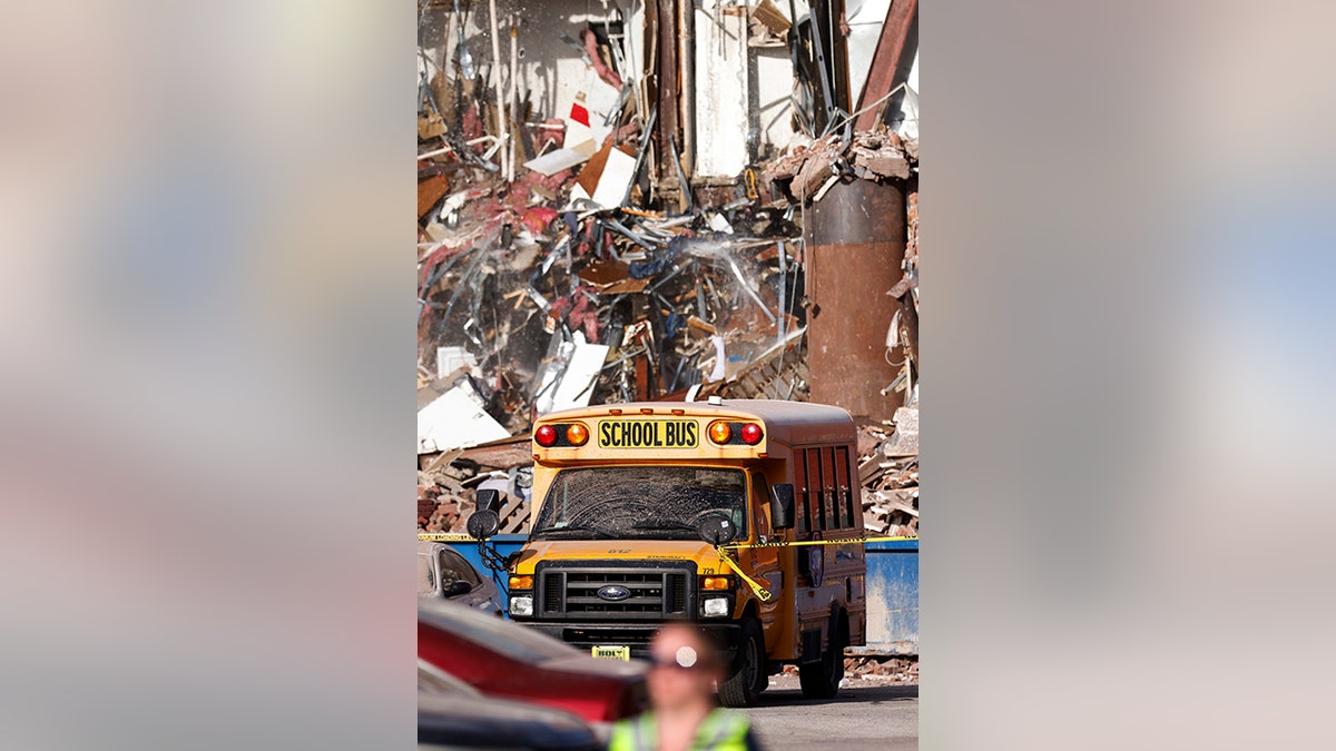 School bus in front of collapsed building