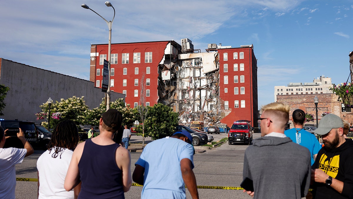 People looking at a partially collapsed building
