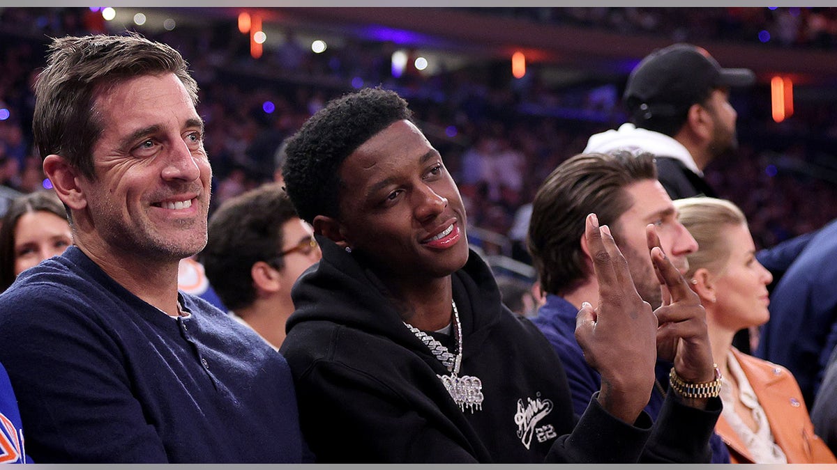 Sauce Gardner and Aaron Rodgers sit courtside