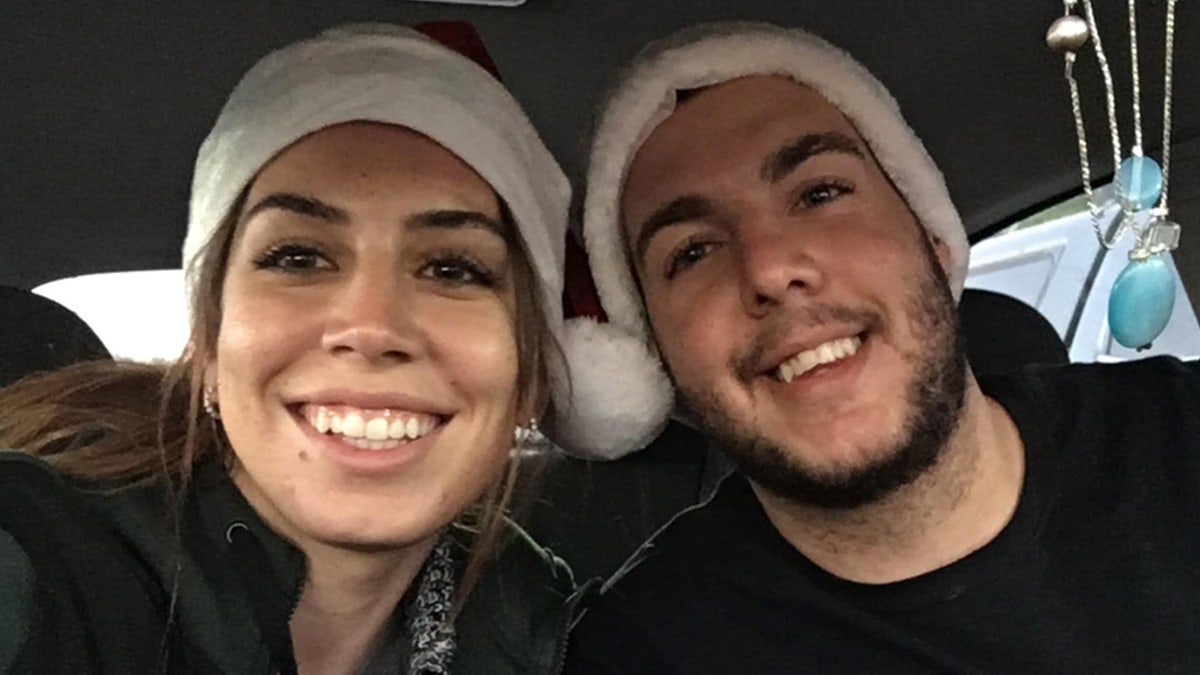 Amanda Hicks and her brother Eric Hicks wear Santa hats.