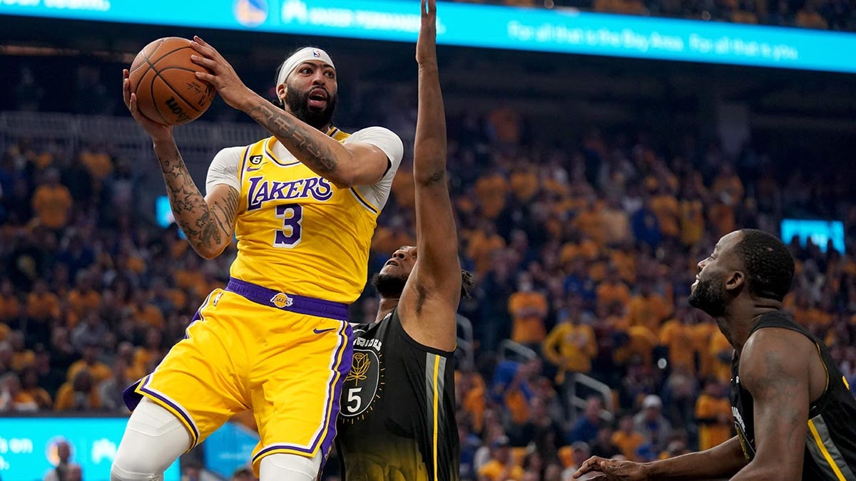 Anthony Davis drives on Kevon Looney