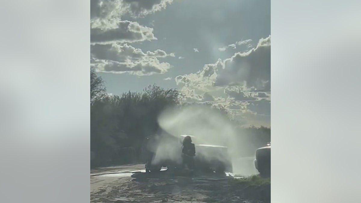 firefighter spraying foam around car