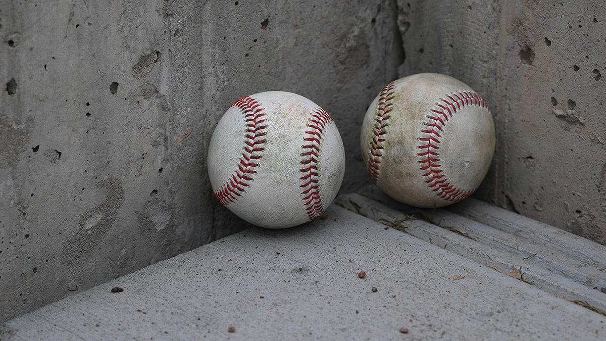 Two baseballs on ground