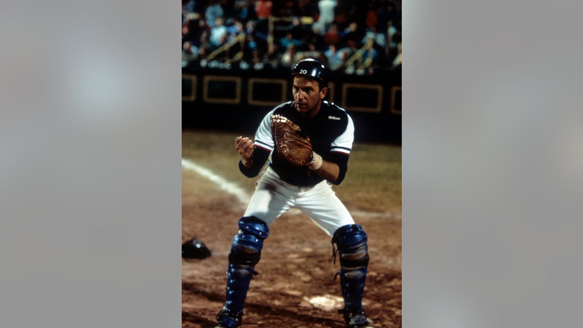 Kevin Costner stands behind home plate in Bull Durham