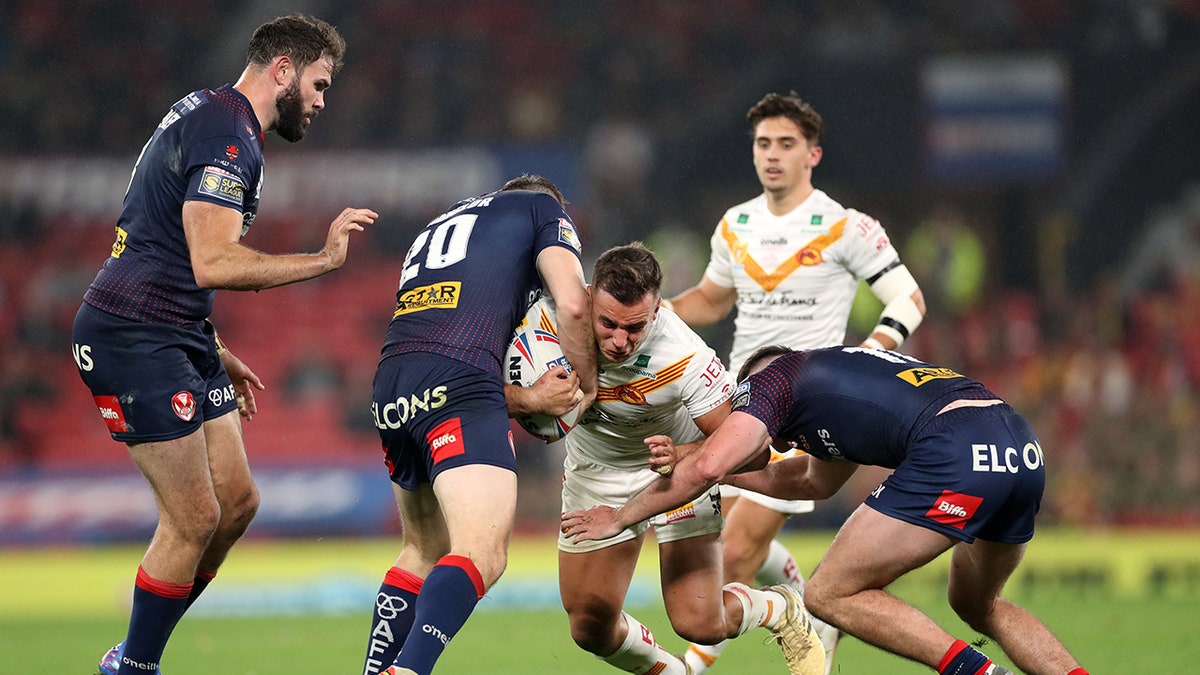 Catalans Dragons is tackled by a St Helens player