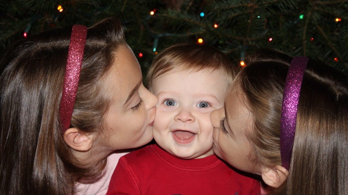 Ben Seitz gets kisses on the cheeks from his sisters