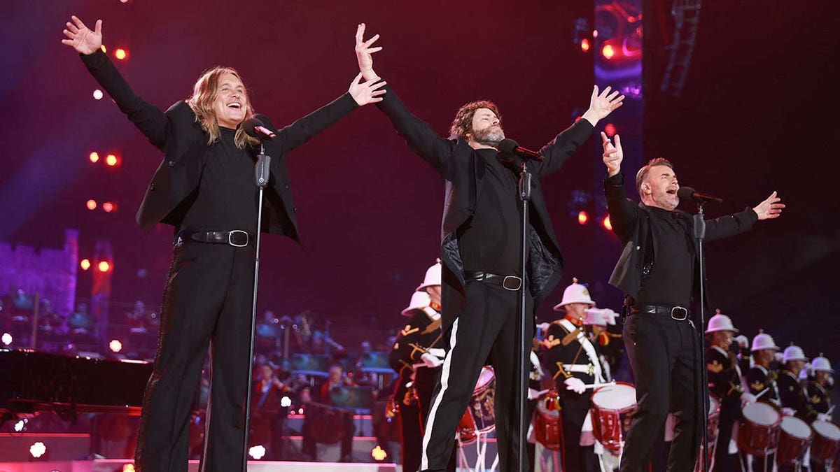 Gary Barlow, Howard Donald and Mark Owen of Take That perform on stage during the Coronation Concert