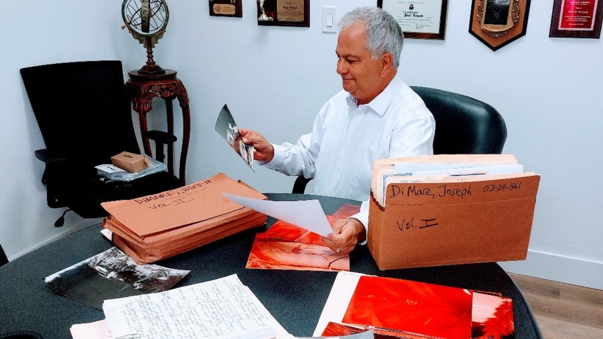 Attorney Paul Novack looks over photos in the Joseph DiMare murder case