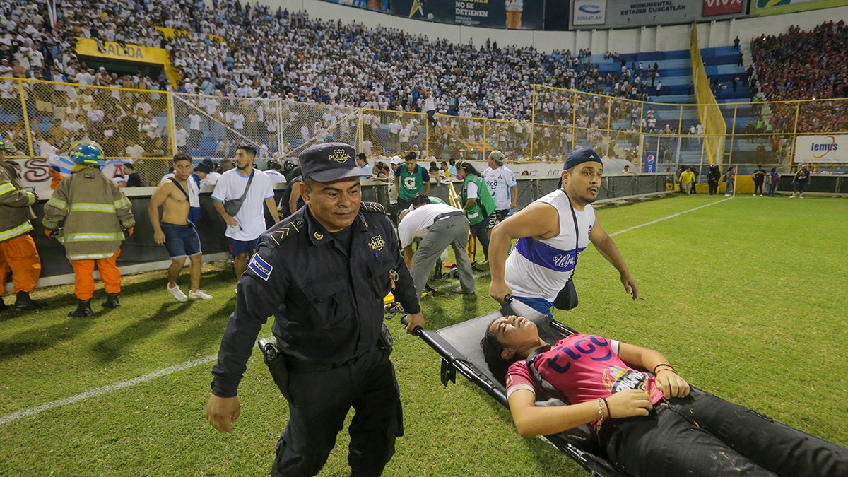 aid workers carrying woman on stretcher