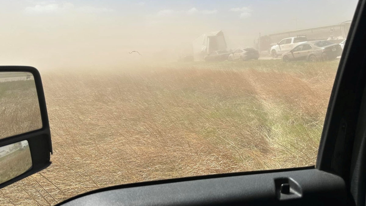 A field and cars in a dust storm