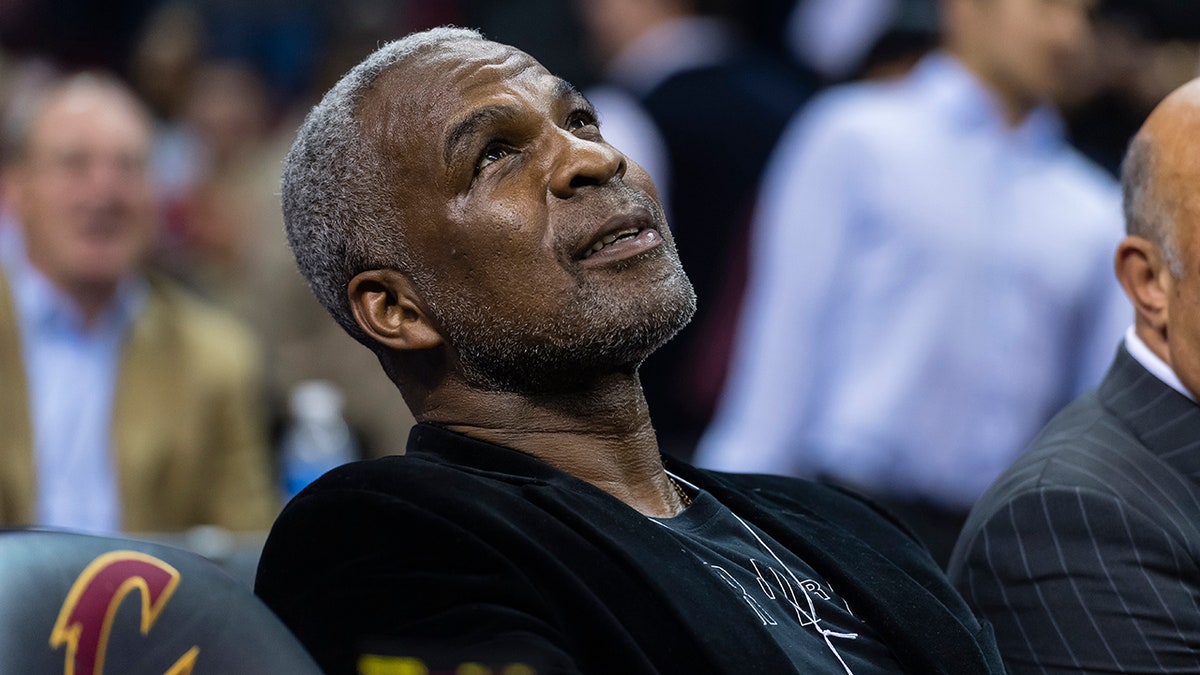 Former NBA player Charles Oakley sits court side