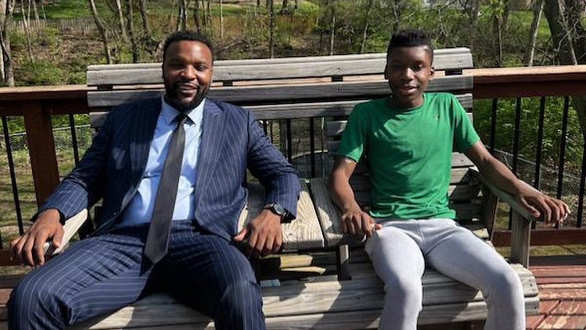 Lee Merritt and Ralph Yarl sit on a bench