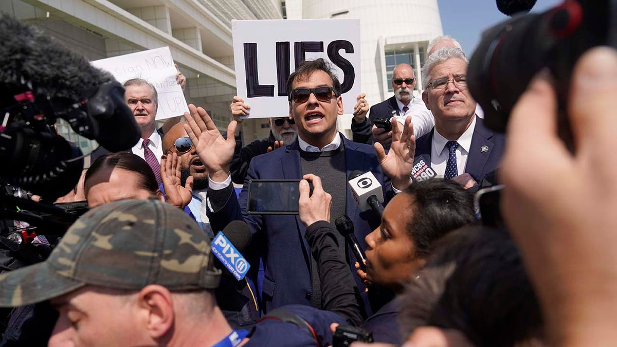 U.S. Rep. George Santos is surrounded by media as he leaves the federal courthouse