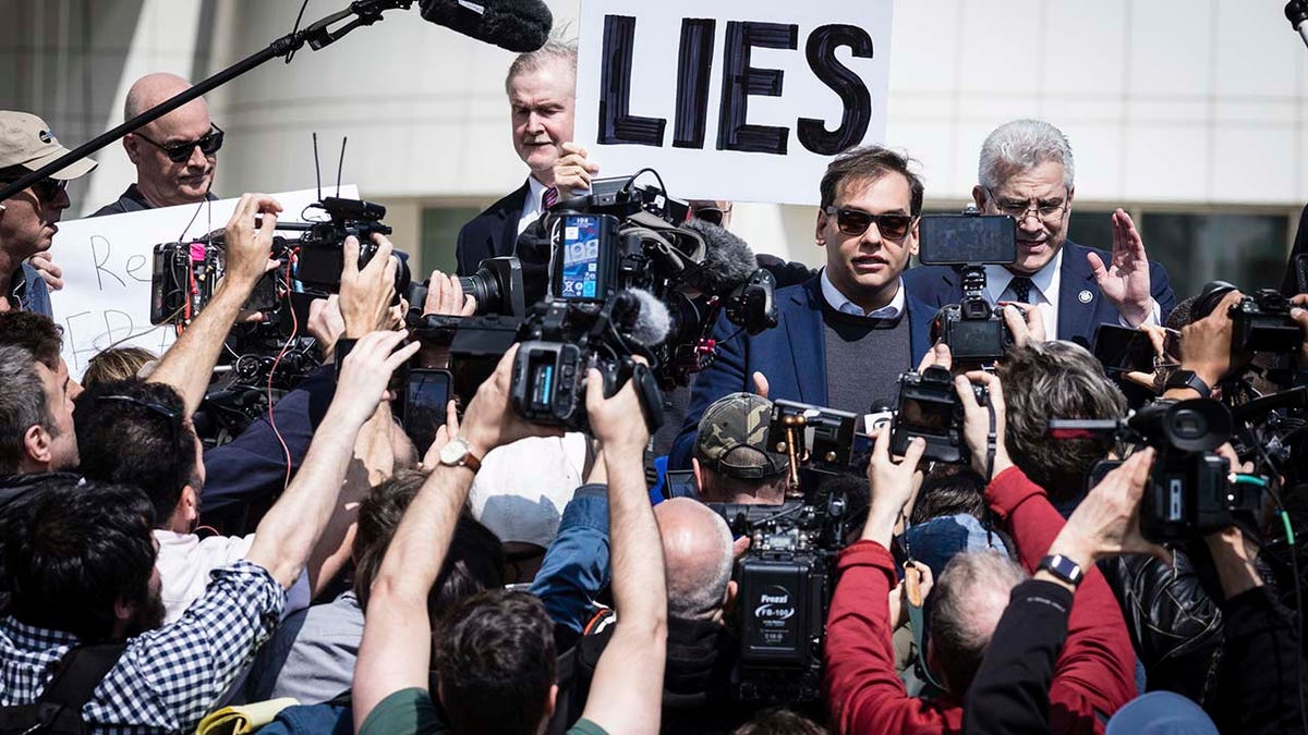 U.S. Rep. George Santos is surrounded by media as he leaves the federal courthouse