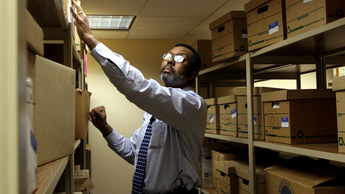 Man searches for records in a vault.