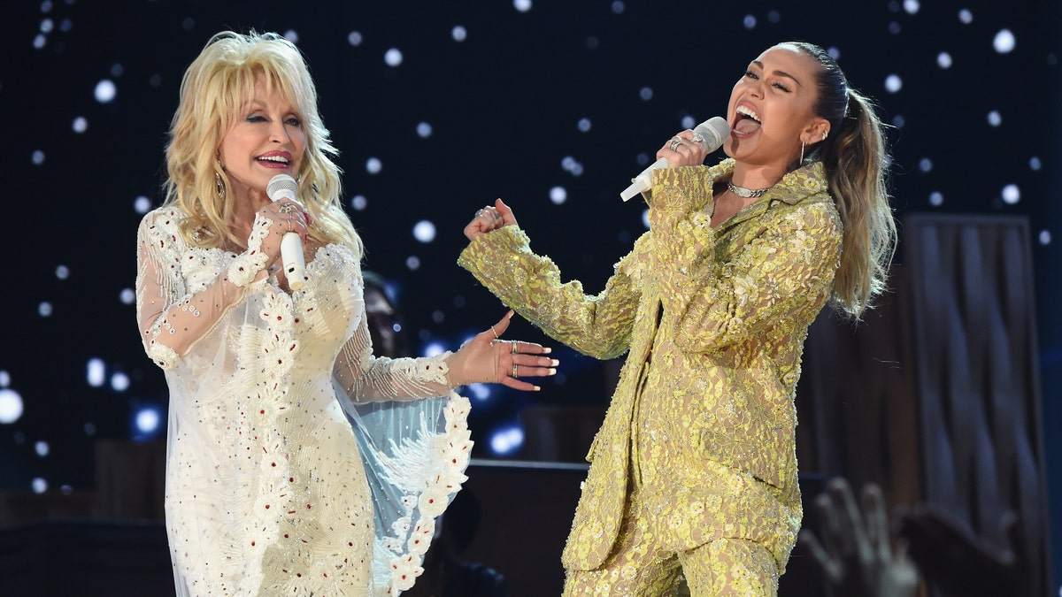 Dolly Parton in white suite performs with Miley Cyrus in gold suit