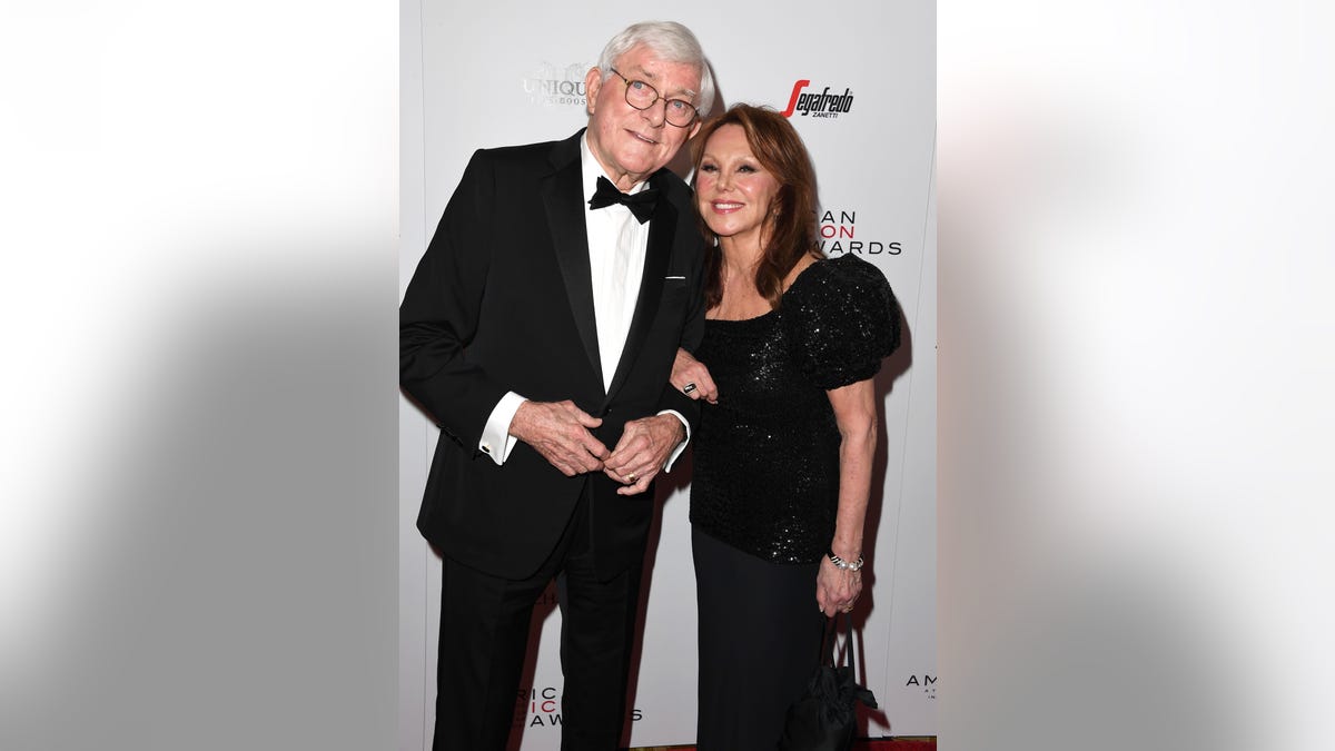 Phil Donahue in a tuxedo and Marlo Thomas in a black gown together on red carpet.