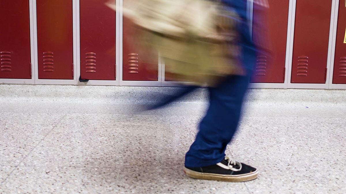 student walking by locker