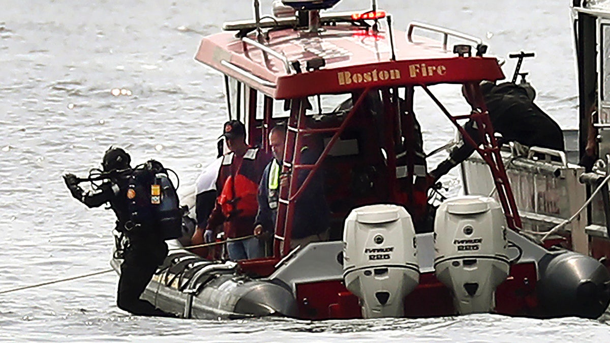 A Boston Fire diver jumps into the water off Castle Island