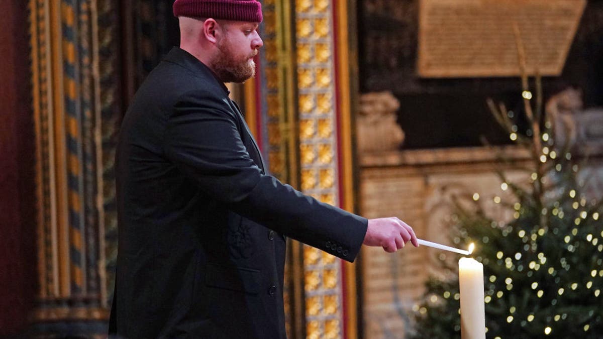 tom walker lighting a candle at christmas concert