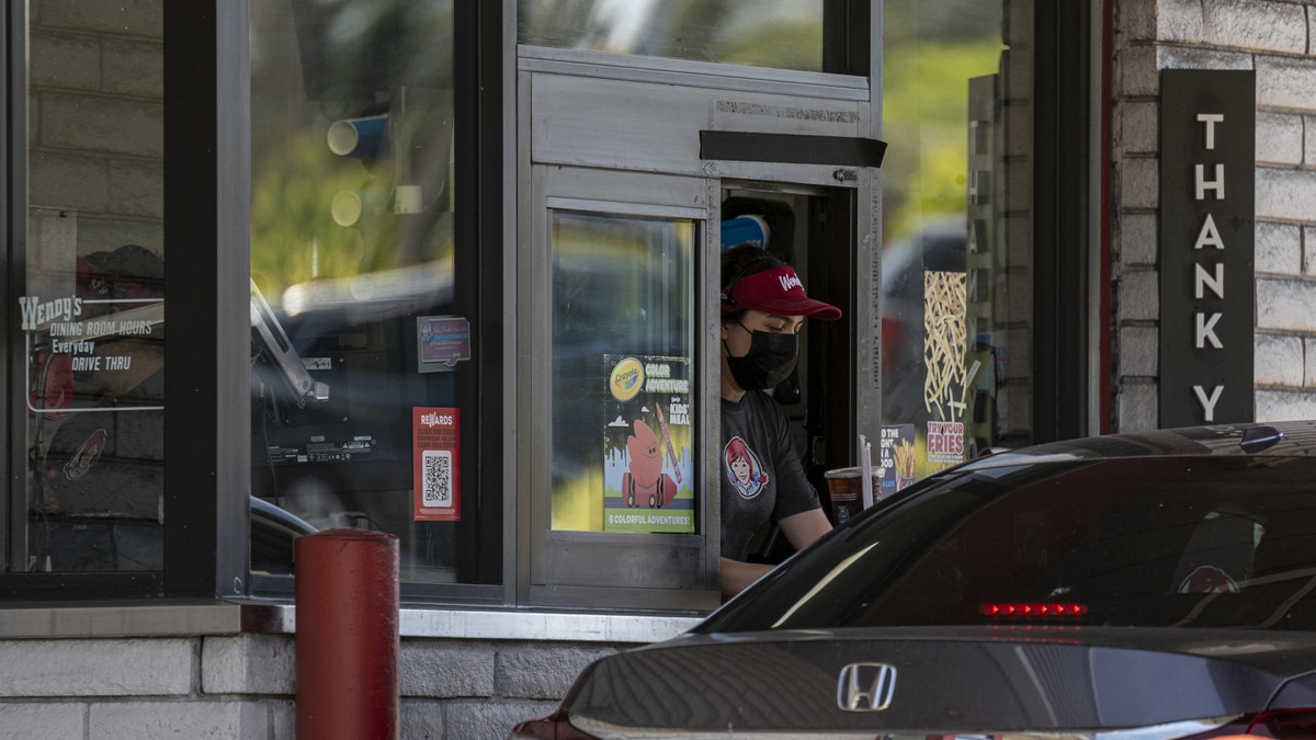 Drive thru window at a Wendy's with a customer in line.