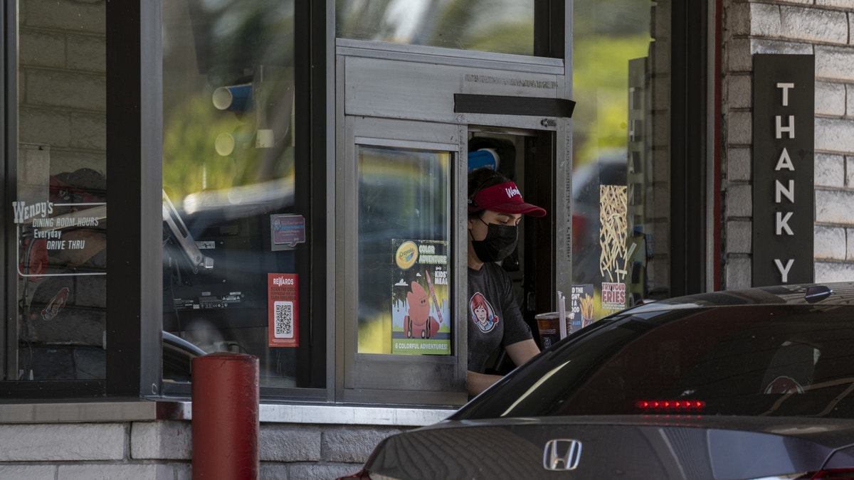 Drive thru window at a Wendy's with a customer in line.