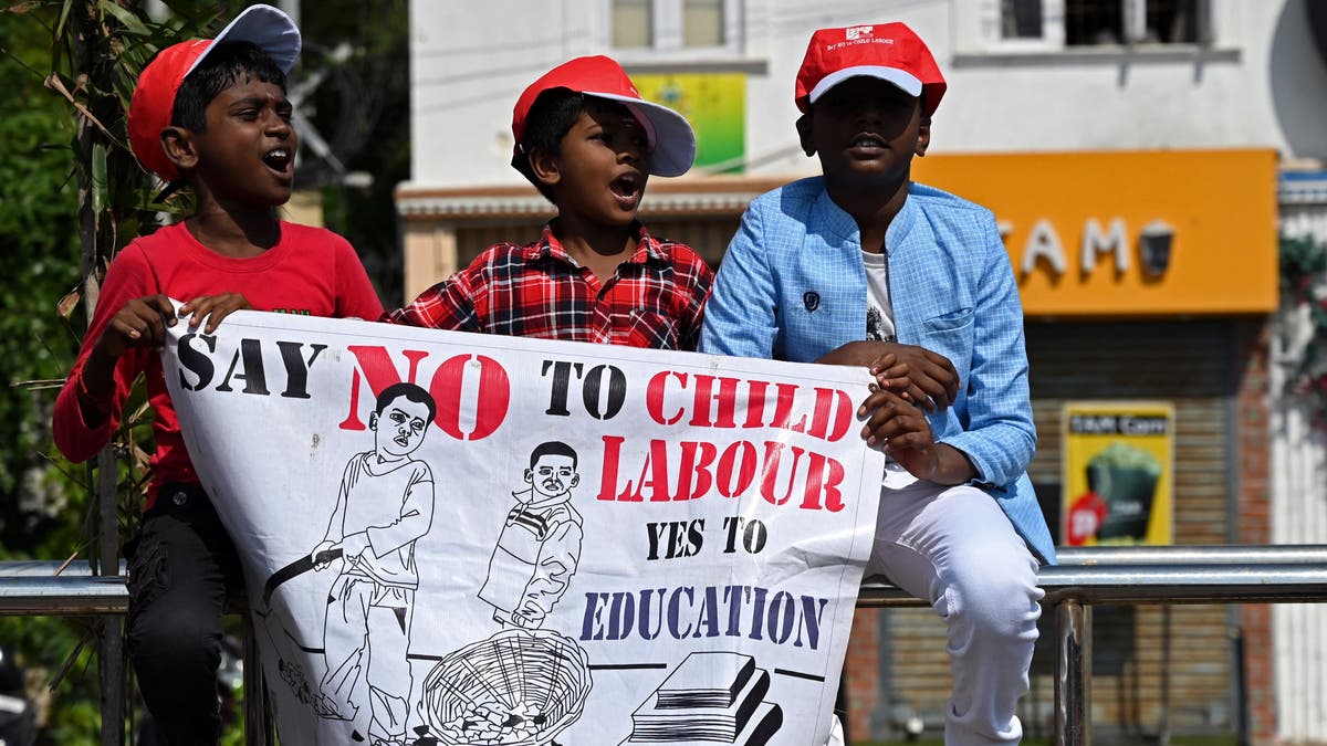 boys hold poster at rally against child labor
