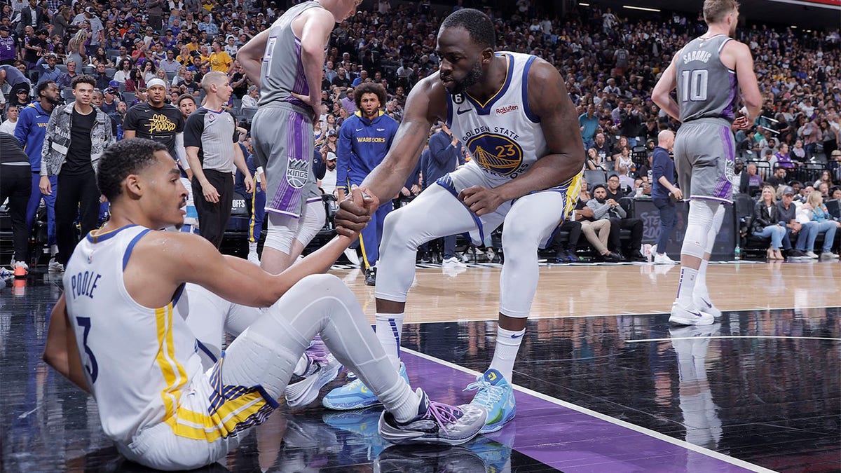 Draymond Green helps up Jordan Poole